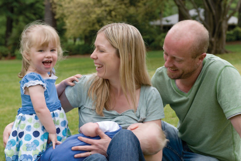 Family outdoors with breastfeeding baby.